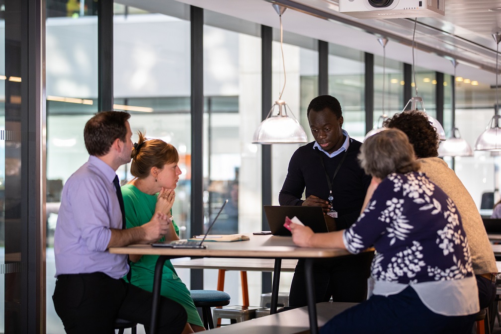 Group of people meeting around a table.